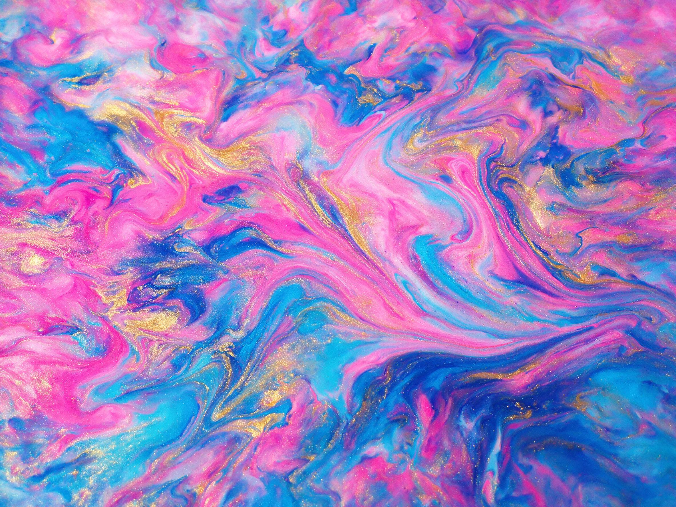 Vibrant fluid art with swirling gradients of neon pink, electric blue, and gold, organic shapes melting into each other, soft diffused lighting from above, glossy resin surface with subtle reflections, minimalist composition, slight grain texture.