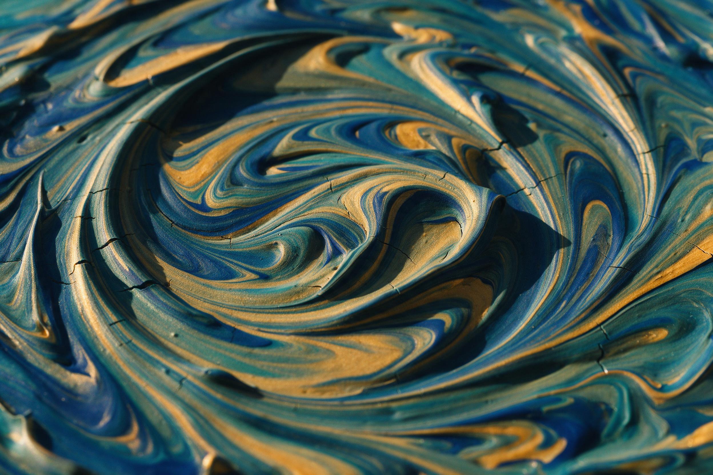 Macro shot of thick acrylic paint swirls in deep blue, teal, and gold, shot with a slightly tilted 35mm lens, warm side lighting casting sharp shadows, subtle paint cracks revealing texture, no black background, no gloss