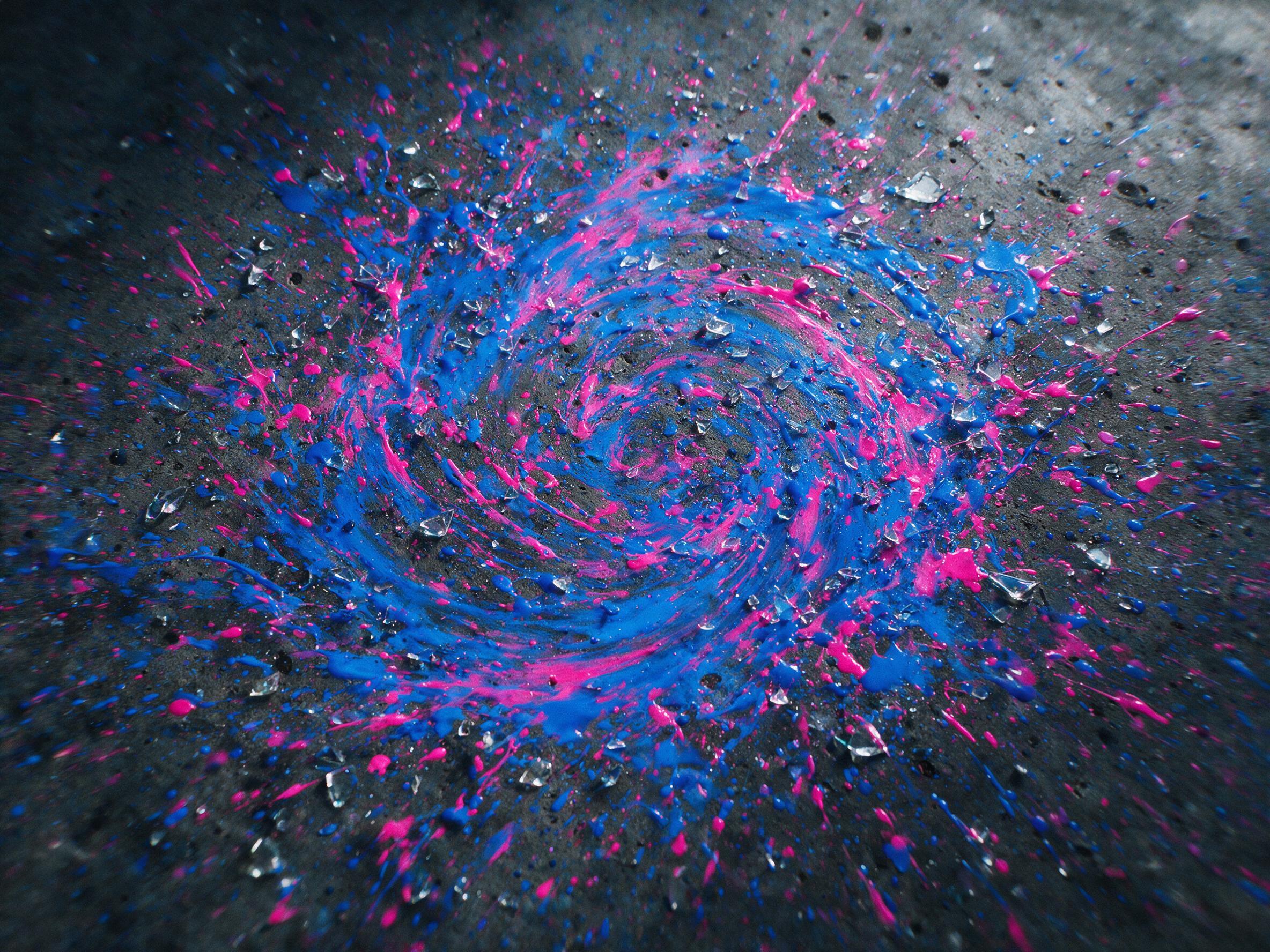 A chaotic swirl of neon blue and electric magenta paint splashes on a dark concrete floor, scattered glass shards reflecting faint light, motion blur effect, soft natural lighting from above, slight grain texture, no sharp outlines or human figures.