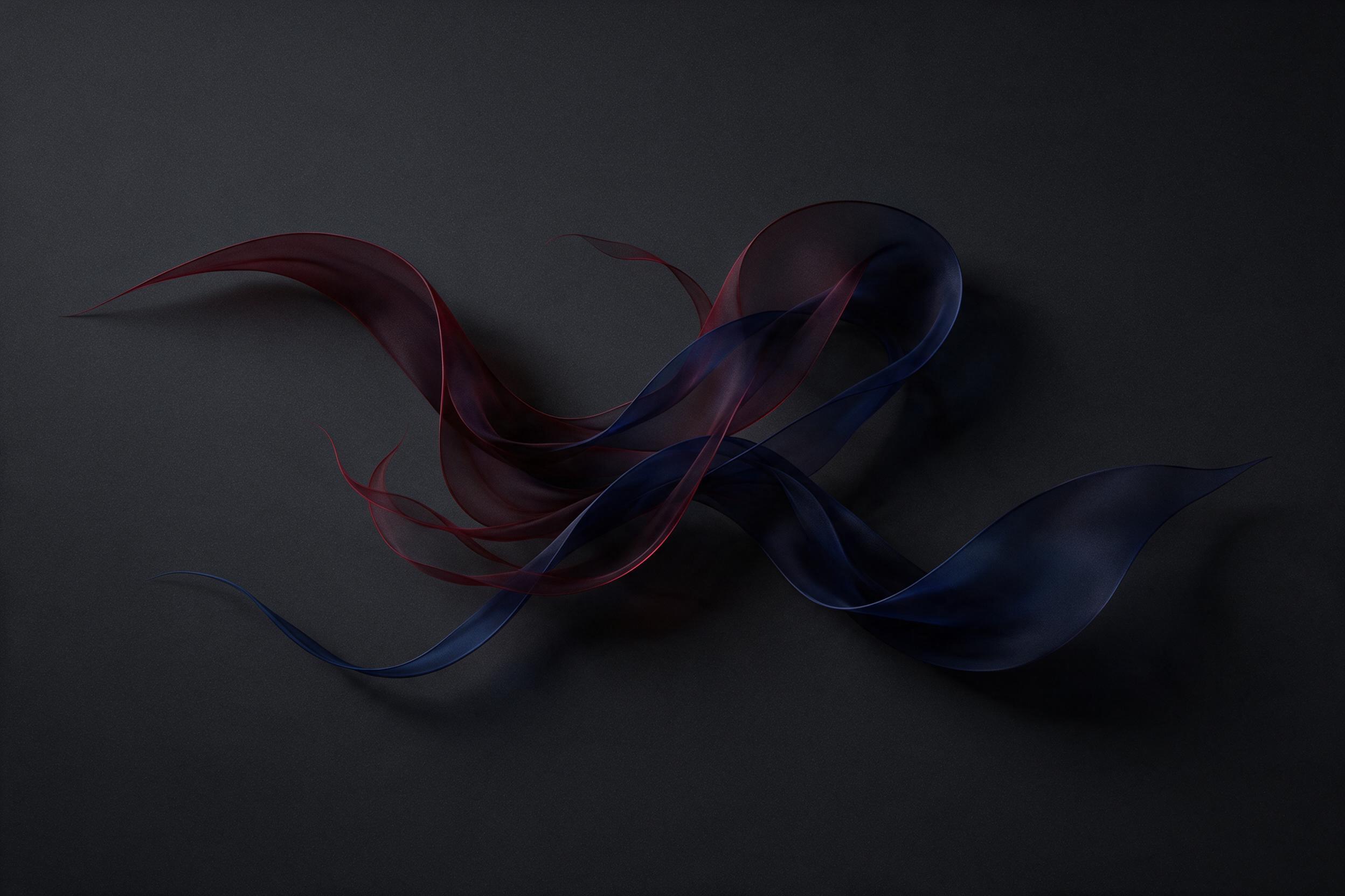 Minimalist abstract composition of flowing translucent ribbons in deep crimson and sapphire, frozen mid-motion against a matte charcoal background, soft directional light casting gentle shadows, subtle grain texture, focused central arrangement with ample negative space