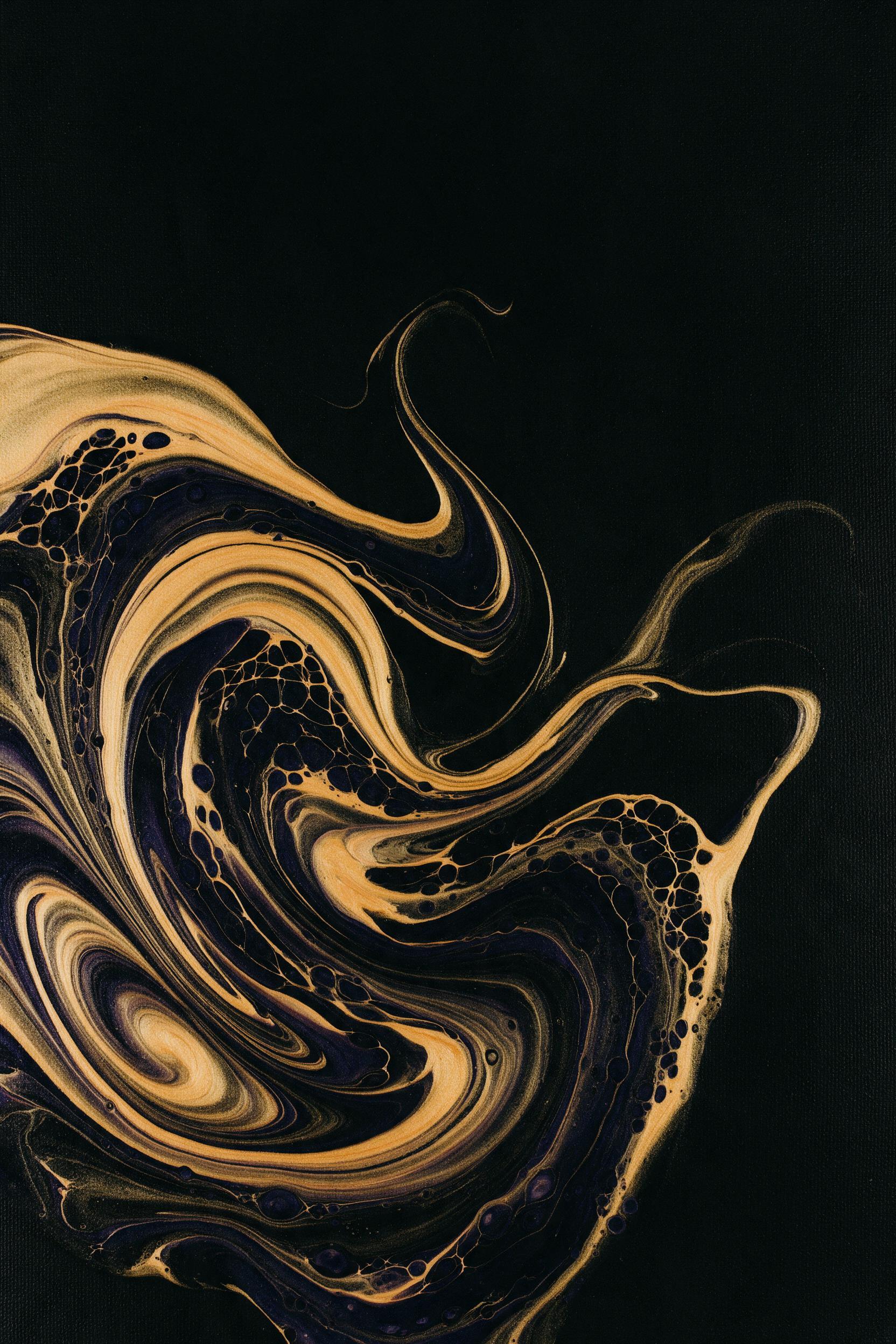 Fluid art of molten gold and deep indigo swirling on a black canvas, subtle ripples catching warm light, minimal composition with negative space, high contrast, camera shot from above, slight film grain