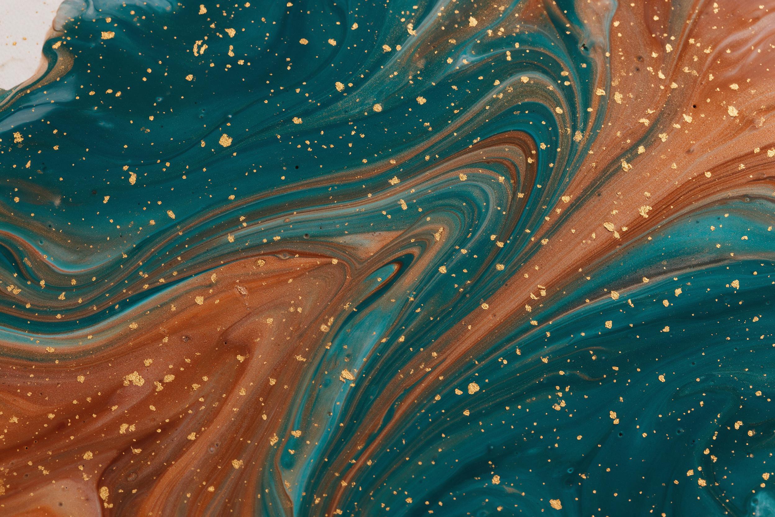 Fluid acrylic pour art on canvas, deep teal and burnt sienna swirling in marble-like veins, interspersed with fine gold leaf flecks catching side light, glossy finish, minimal white space in upper left corner, soft shadows from raking studio light, macro texture visible, composition balanced yet dyn