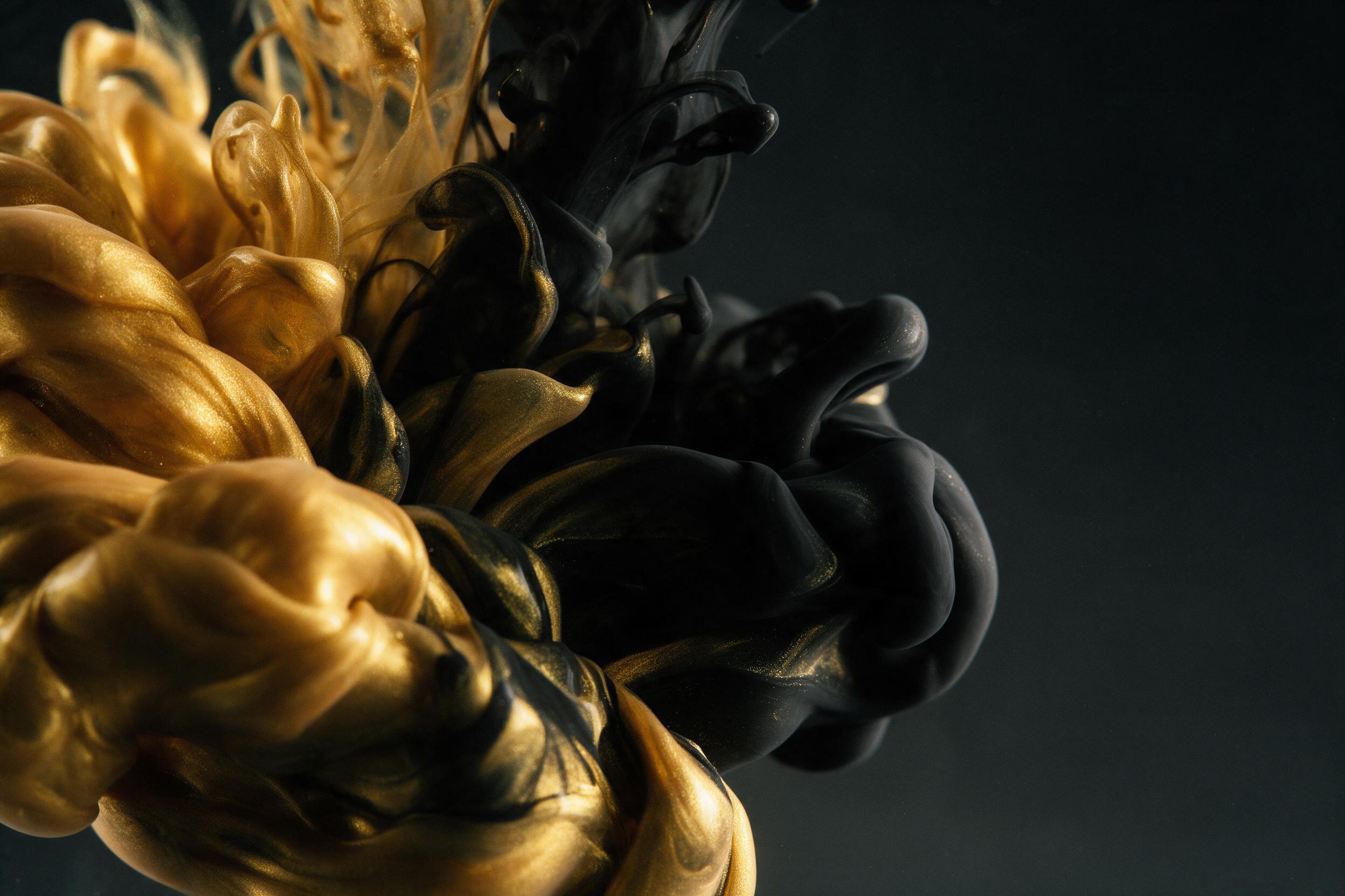 Close-up of liquid gold and black ink swirling together in slow motion, macro photography, dramatic side lighting casting deep shadows, glossy reflections on fluid surface, minimal composition with negative space, subtle grain for texture