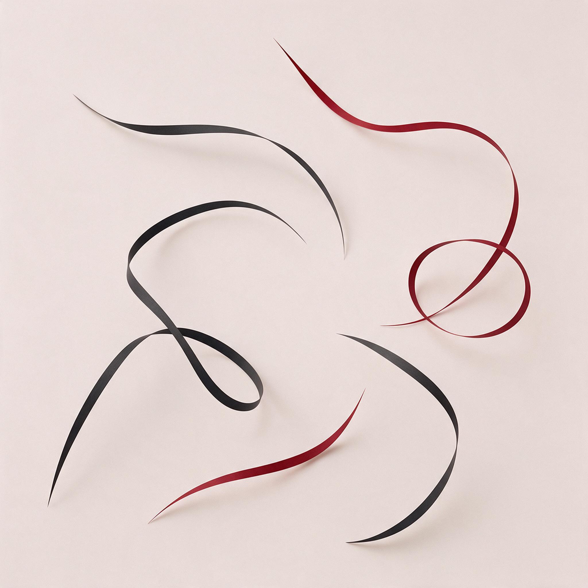 A minimalist abstract composition with flowing ribbons of matte black and deep crimson, suspended in a pale beige void, soft diffused studio lighting casting gentle shadows, subtle grain, clean geometry meets organic curves, focal point at center