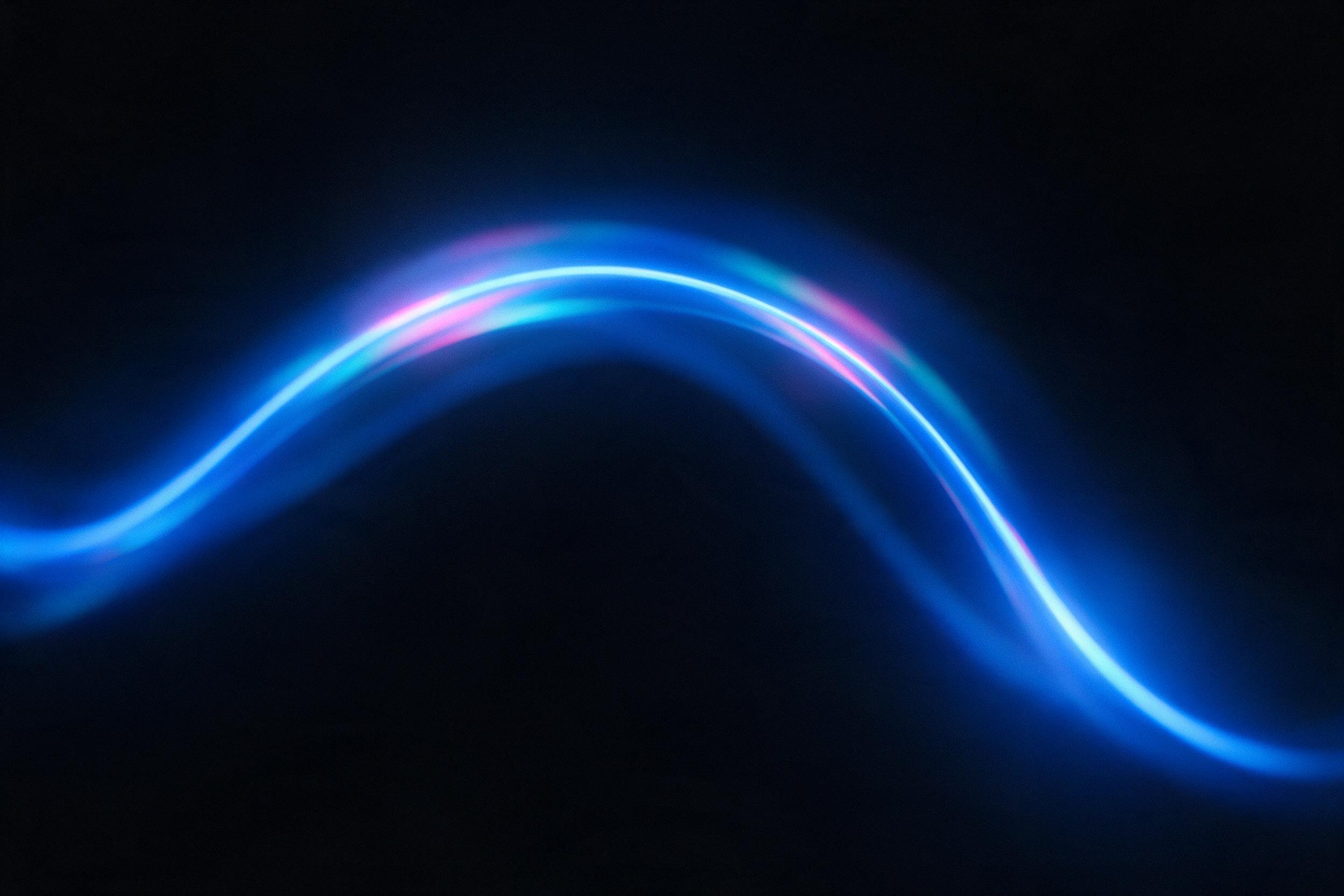 A single glowing neon blue line curves gracefully through a dark, matte black void, subtle pink and cyan reflections on the line's surface, minimalistic composition, soft ambient light, shallow depth of field, slight grain texture